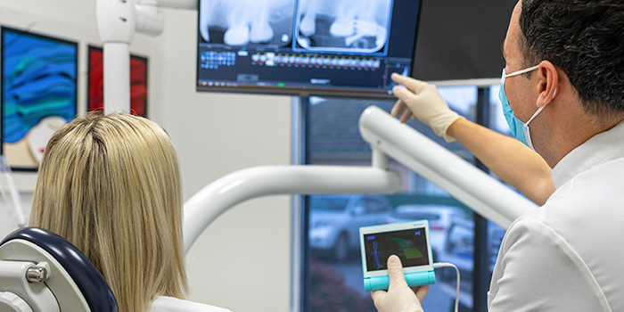 A dentist showing and explaining an X-ray to a patient
